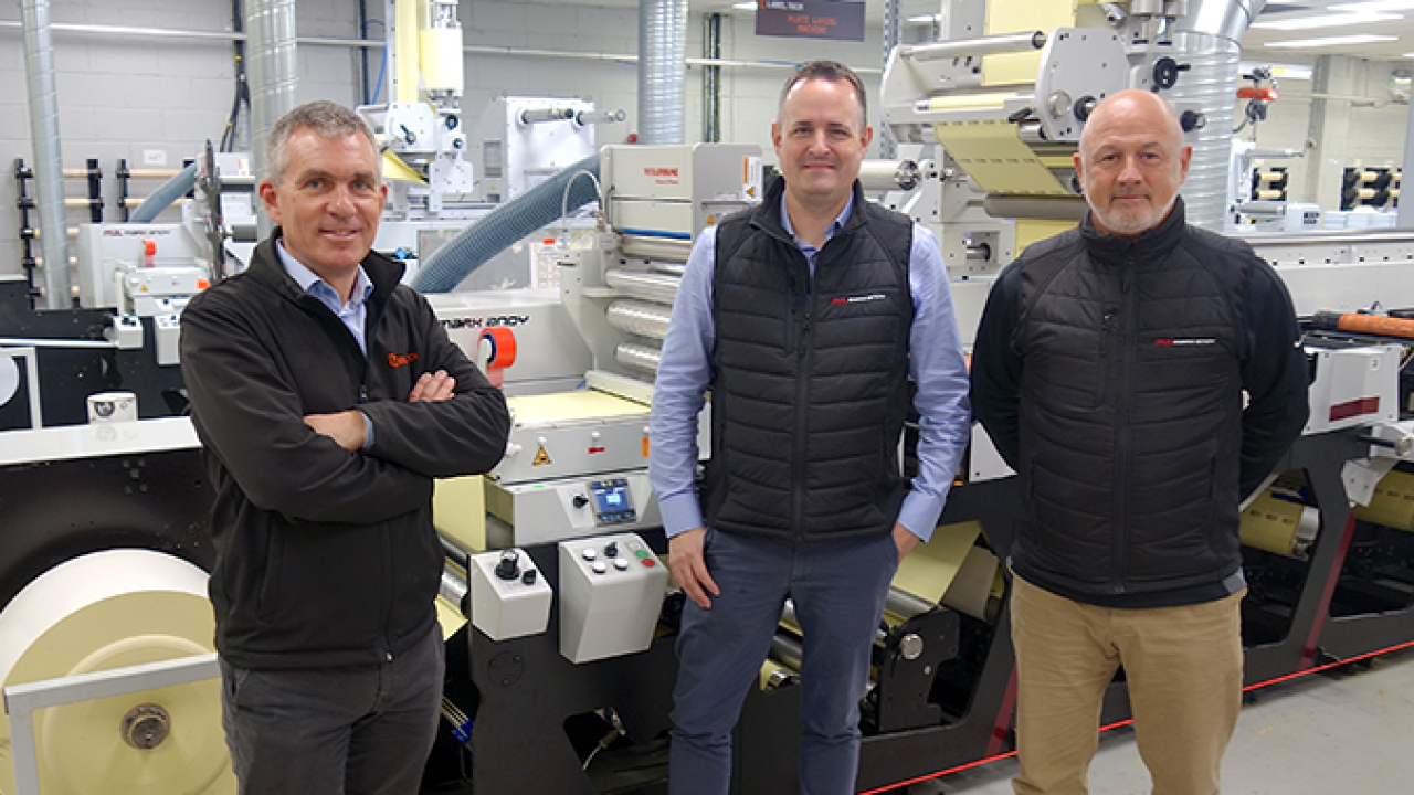 L-R: Label Tech's James Costello with Mark Andy's Phil Baldwin and Ian Pollock and the company's second Evolution Series E5 flexo press at its production facility in Santry, Ireland