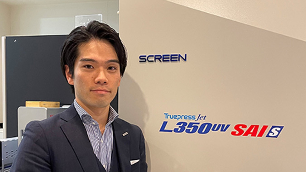 Taishi Motoshige, marketing manager of Screen Europe in front of a Truepress Jet L350UV SAI S Taishi Motoshige, marketing manager of Screen Europe in front of a Truepress Jet L350UV SAI S